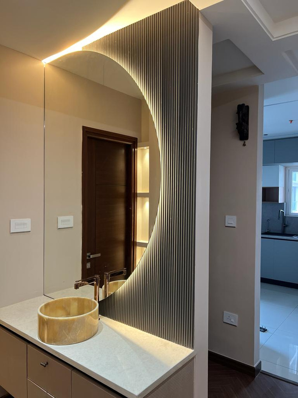 Powder bath — fluted wall detail and a sculptural round mirror.
