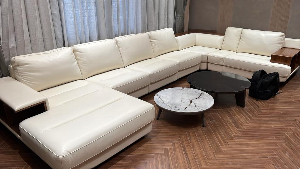 Living room — a large white sectional with twin coffee tables in marble and black.