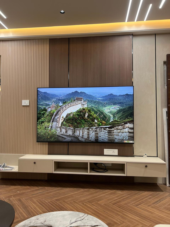 TV unit — full-height wood panelling frames the screen as a single composition.
